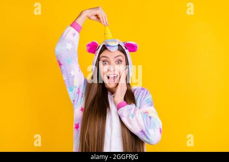 Ritratto di attraente ragazza allegra comic che ha divertimento indossano l'animale sguardo che tocca il corno isolato su sfondo di colore giallo chiaro Foto Stock