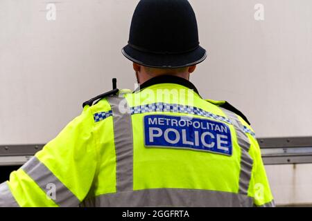 Londra, Inghilterra - Agosto 2021: Vista posteriore di un ufficiale di polizia Metropolitan che indossa una giacca riflettente. Foto Stock