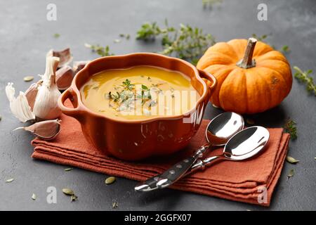 Zuppa di zucca con timo e semi di zucca su sfondo nero Foto Stock