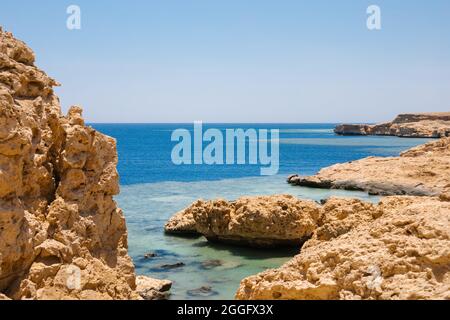 Costa sabbiosa e rocciosa con acqua di colore blu. Spiaggia desolata sulla costa del Mar Rosso. RAS Muhammad in Egitto all'estremità meridionale del Foto Stock