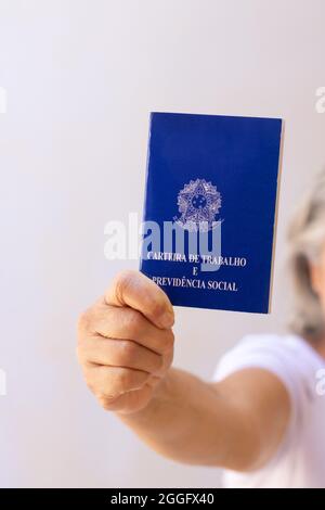 In possesso di una scheda permesso di lavoro per il brasile, isolata su sfondo bianco. Foto Stock