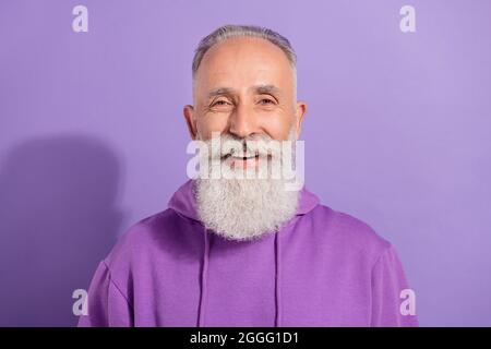 Ritratto di attraente felice allegro uomo grigio-capelli buon umore isolato su viola sfondo di colore viola Foto Stock