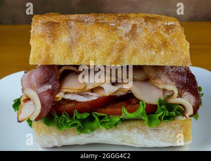 tacchino e pancetta con pomodori su pane ciabatta Foto Stock