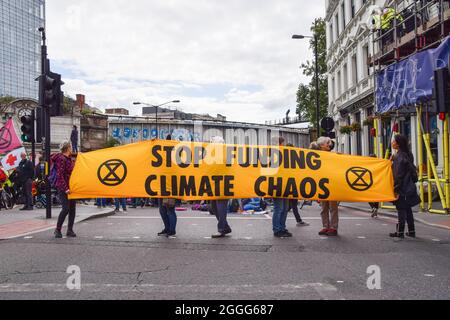 Londra, Regno Unito. 31 ago 2021. I manifestanti hanno in mano un cartello "Stop Funding Climate Chaos" durante la protesta.i manifestanti della ribellione di estinzione hanno bloccato le strade accanto al London Bridge con un autobus, come parte della loro campagna di due settimane impossibile contro la ribellione, chiedendo al governo britannico di agire in modo significativo sul clima e la crisi ecologica credito: SOPA Images Limited/Alamy Live News Foto Stock