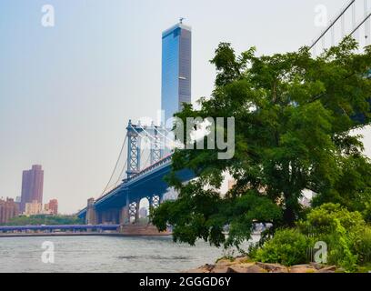 Skyline di Manhattan Bridge a Pebble Beach. A Brooklyn, New York, USA. Luglio 2021. Foto Stock