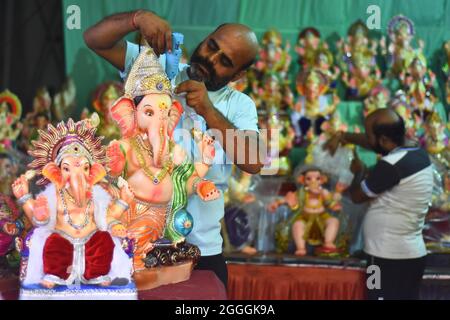 Jabalpur: Un artista decora con cura un idolo di Lord Ganesha in un laboratorio in preparazione del festival Ganesh Chaturthi a Jabalpur, Foto Stock
