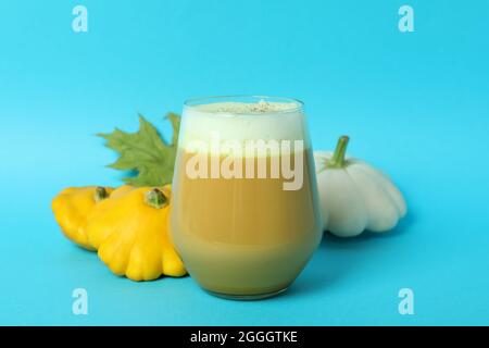 Bicchiere di latte di zucca e ingredienti su sfondo blu Foto Stock