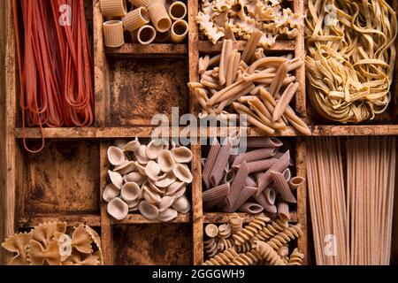 Presentazione di un mix di pasta diversa integrale stivata in piccoli contenitori Foto Stock