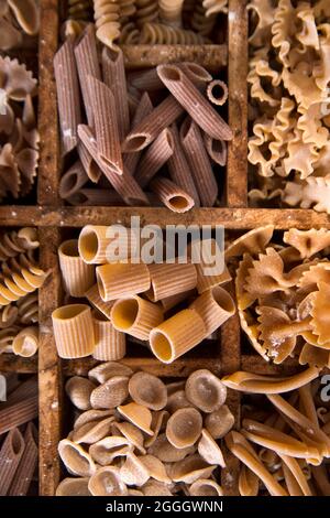 Presentazione di un mix di pasta diversa integrale stivata in piccoli contenitori Foto Stock