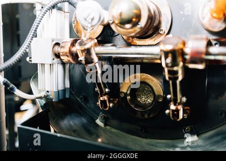 I proprietari di una caffetteria mostrano la tecnologia per preparare caffè in grani in una macchina professionale Foto Stock