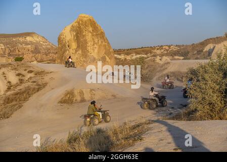 Turisti in safari in Cappadocia con veicoli ATV con vista di camini fata Foto Stock