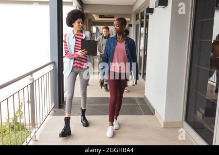 Diverse colleghi al lavoro, camminando insieme, parlando Foto Stock