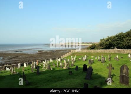 Vista della baia di Morecambe con la bassa marea verso Morecambe attraverso il cimitero dalla chiesa di San Pietro in prossimità di Main Street, Heysham, Lancaster, Lancashire, Engla Foto Stock