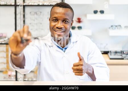 Medico oftalmologista che mostra occhiali con pollici in su per la visione nella macchina fotografica Foto Stock