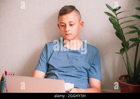 Ragazzo teen che guarda stiratamente lo schermo del computer Foto Stock