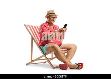 Uomo anziano che si rilassa su una sedia da spiaggia e utilizza uno smartphone isolato su sfondo bianco Foto Stock