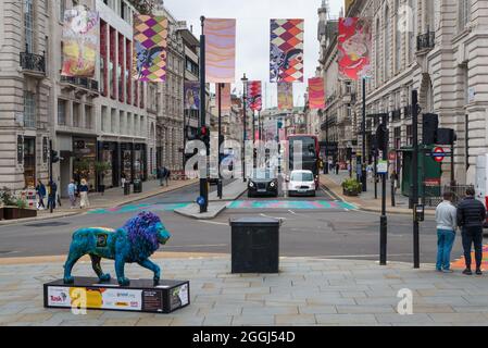 Vista lungo Piccadilly visto da Piccadilly Circus. Striscioni colorati si estendono dall'altra parte della strada. Persone che acquistano e visitano. Londra, Inghilterra, Regno Unito Foto Stock