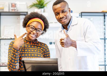 Professionista oftalmologo medico uomo aiutare giovane cliente donna a scegliere un occhiali è successo Foto Stock