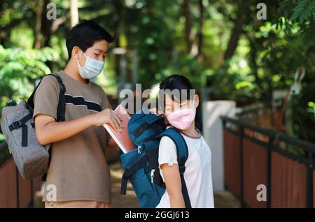 Fratello e sorella di nuovo a scuola COVID-19 pandemia Foto Stock