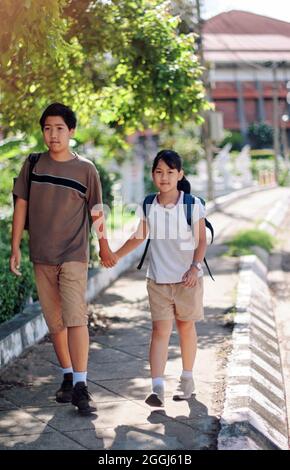 Fratello e sorella tornano a scuola Foto Stock