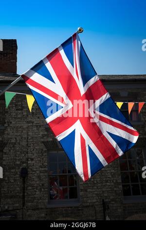 Union Jack e Bunting retroilluminati nella città del mercato Foto Stock