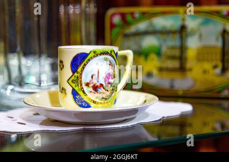 Vecchia tazza di cioccolato e piattino con scena dipinta al Museo del cioccolato Szamos a Budapest, Ungheria Foto Stock