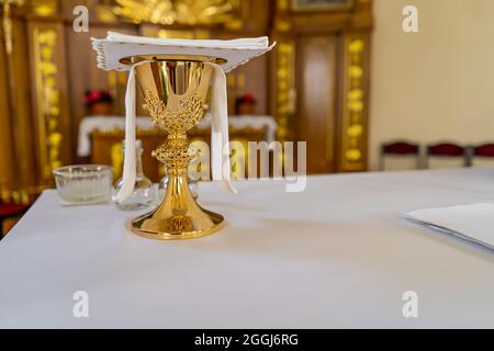 Una tazza di vino sull'altare in una chiesa cattolica. Foto Stock