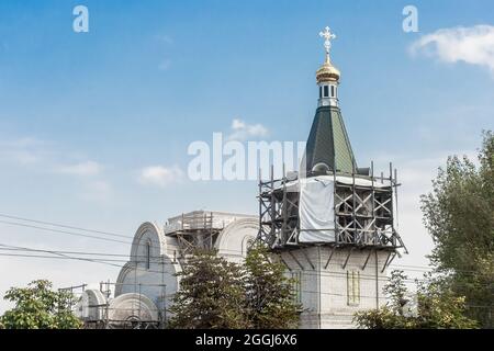 Riparazione, restauro o costruzione di una nuova chiesa in città contro il cielo blu. Foto Stock