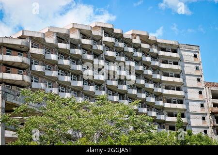 Abbandonato edificio sgretolante con balconi semicircolari - pericolo di collasso. Foto Stock