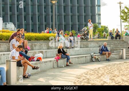 POZNAN, POLONIA - 26 ago 2018: Un gruppo di persone sedute su sedili in pietra in un parco a Poznan, Polonia Foto Stock