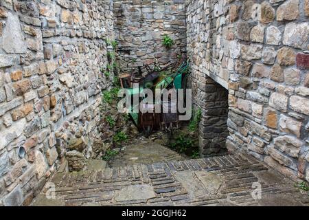 Carriole arrugginite accatastate sul bordo di una fortezza medievale. Foto Stock