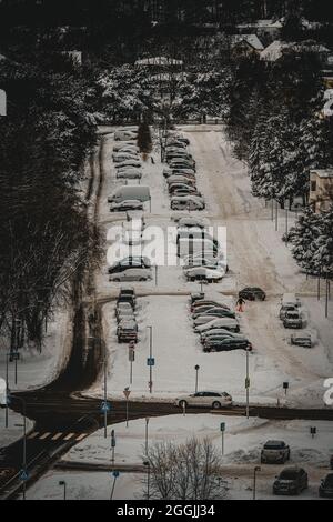 Una vista dalla costa arrociata (costa abrasiva) su Haabneeme insediamento con un parcheggio tra i parchi durante una fredda serata invernale Foto Stock