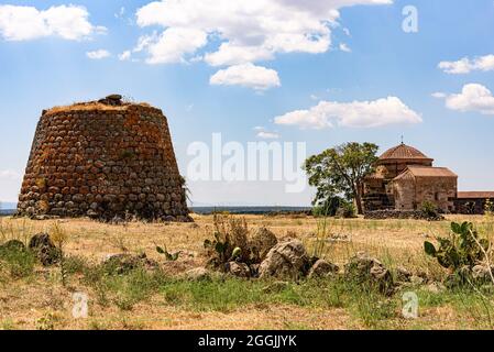 Il nuraghe e la chiesa di Santa Sabina in Sardegna in una giornata estiva Foto Stock