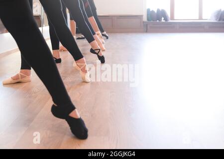 Sezione bassa delle gambe aggraziate di ballerini in piedi in fila sulle loro dita Foto Stock