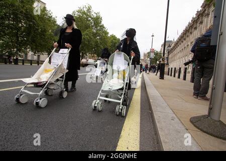 Estinzione attivisti della ribellione Londra 31 agosto 2021. I manifestanti d'azione della ribellione PRAM nel centro di Londra, camminano con le pram bianche fantasma vestite in abiti funerari Foto Stock