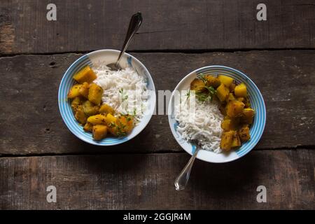 Pasto indiano mescolare curry di zucca fritto e riso servito in una ciotola. Vista dall'alto. Foto Stock