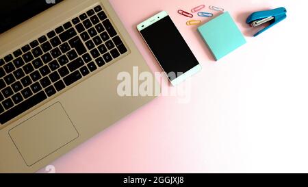 Elegante spazio di lavoro con computer portatile, smartphone e moderni accessori per l'ufficio Foto Stock