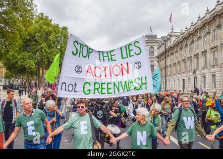 Londra, Regno Unito. 01 Settembre 2021. I manifestanti portano una bandiera che dice 'Stop the Lies - Action Not Greenwash' mentre marciò durante la manifestazione fuori Downing Street.i manifestanti della ribellione di estinzione hanno organizzato una 'Greenwash' protesta a Westminster, parte della loro due settimane impossibile campagna di ribellione che invita il governo britannico ad agire in modo significativo sul clima e la crisi ecologica. (Foto di Vuk Valcic/SOPA Images/Sipa USA) Credit: Sipa USA/Alamy Live News Foto Stock