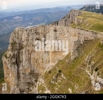 Mountain biker su sentieri singoli in tour attraverso la riserva naturale Hauts-Plateais du Vercors, Auvergne-Rhône-Alpes. Al margine tra Pas des Ècondus e Pas de l'Èchelette vicino al col du Rousset - vista a sud. Foto Stock