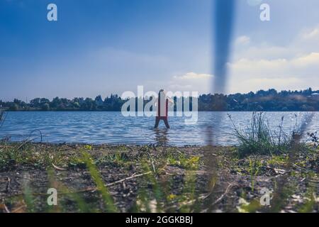 un bambino spruzzi d'acqua mentre corre in acqua, sentimenti di libertà Foto Stock