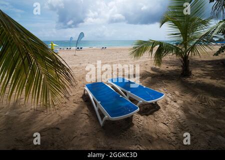 Lounge di Empty Beach sulla spiaggia di Isla Verde a San Juan Puerto Rico, 27 giugno 2021. Anche se Porto Rico richiede che i visitatori siano vaccinati COVID-19 o mostrino un test PCR o antigenico negativo recente e richiede maschere o coperture facciali essere indossati in spazi interni. Il 31 agosto 2021 i Centri per il controllo e la prevenzione delle malattie hanno aggiunto Porto Rico alla lista delle destinazioni a rischio COVID-19 molto elevato e il Dipartimento di Stato degli Stati Uniti ha emesso un avviso "Do Not Travel" per il territorio degli Stati Uniti. Foto Stock