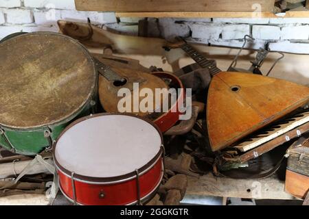 Vecchi strumenti musicali rotti. Batteria, chitarre e altri strumenti musicali. Messa a fuoco selettiva. Foto Stock