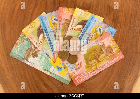 Banconote e monete del Costa Rica su sfondo ligneo Foto Stock