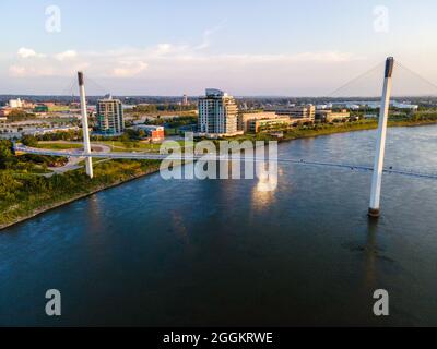 Fotografia aerea del Bob Kerrey Pedestrian Bridge che attraversa il fiume Missouri tra Council Bluffs, Iowa e Omaha, Nebraska, in una bella strada Foto Stock