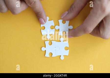 Immagine di businesswoman che collega elementi di bianco puzzle closeup Foto Stock
