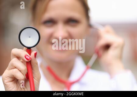 Ritratto di femmina sorridente dottore che tiene stetoscopio closeup Foto Stock