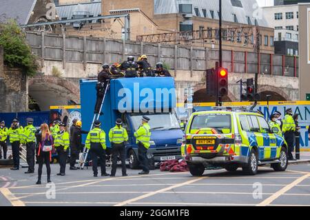 LONDRA, INGHILTERRA- 30 agosto 2021: I manifestanti di estinzione della ribellione "bloccati" sul tetto di un camion durante una protesta a Londra Foto Stock