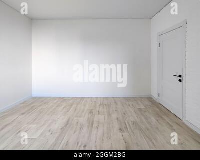 Camera vuota interna - parete bianca con una porta e un pavimento Foto Stock