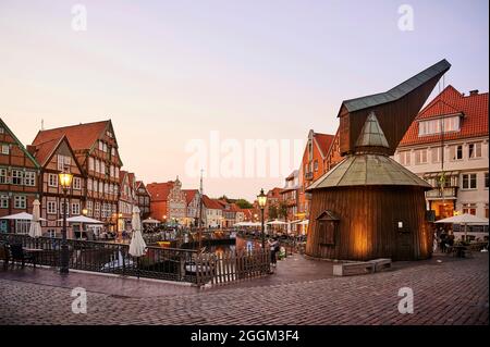 Città anseatica di Stade, città vecchia sulla Schwinge, mercato del pesce e storico gru a pedale, atmosfera serale con illuminazione Foto Stock