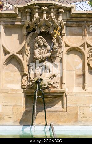 Germania, Baden-Wuerttemberg, Schwäbisch Hall, Arcangelo Michele, sconfigge il diavolo (drago) e lo spinge verso la terra. Fontana figura dal 1509 dello scultore Hans Beuscher presso la fontana gotica del pesce. Foto Stock